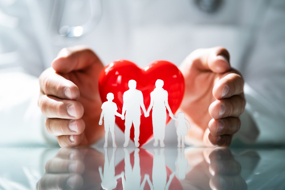 Mãos protegendo a silhueta de uma família.